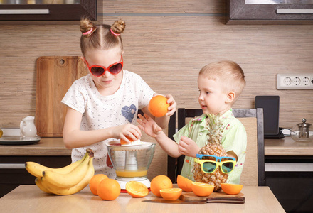 健康食品 一个女孩和一个男孩做新鲜的橙汁