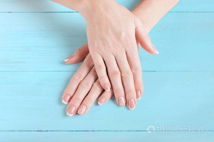 漂亮的指甲。蓝漆板上的女人的手。特写