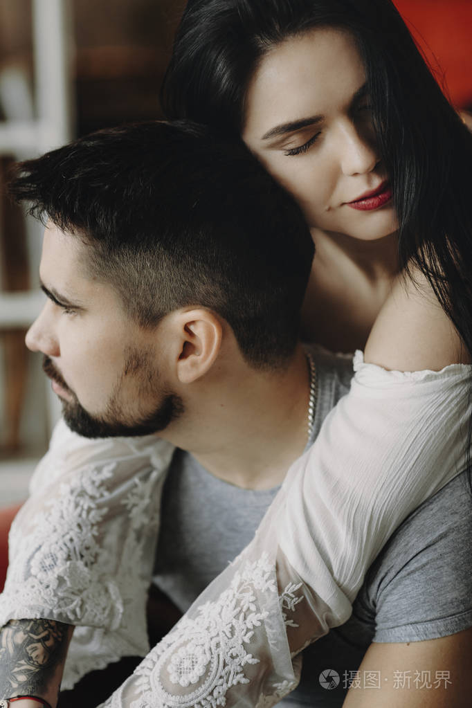 年轻情侣在爱拥抱而女人是withclosed