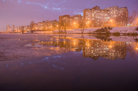 基辅典型的住宅区。日落后, 冬季城市景观以水为主。在水中的倒影。Troeschina, 基辅, 乌克兰
