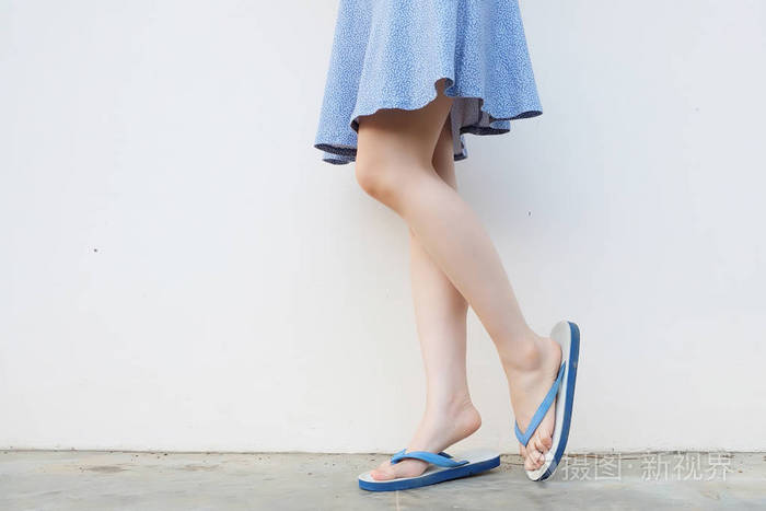自拍女孩苗条的腿蓝色鞋子和礼服被隔绝在混凝土地板上.