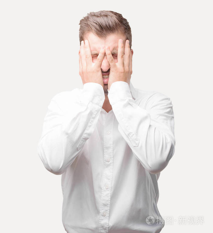 年轻英俊的男人带着悲伤的表情穿着白色 t恤, 郁闷的姿势.