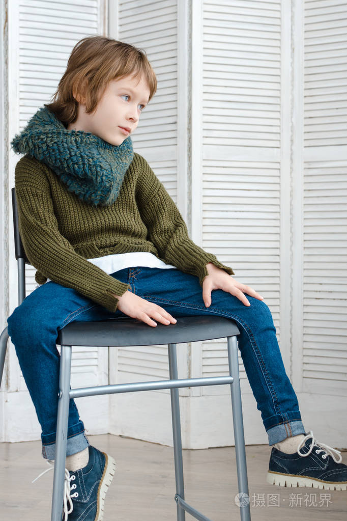 穿着时髦衣服的男孩在画室里摆姿势