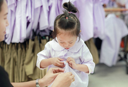 母亲尝试穿校服为她的女儿, 幼稚园孩子