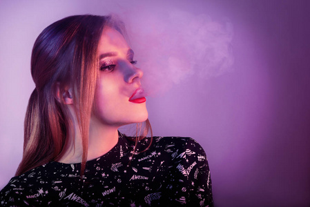 演播室射击.时尚艺术肖像美女模特在明亮的灯光与五颜六色的烟雾.