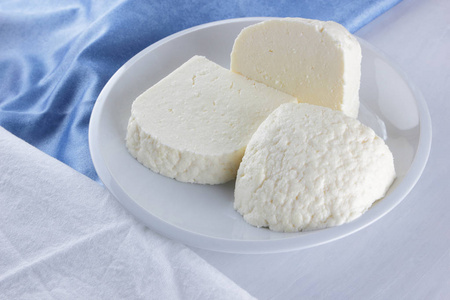 奶酪, 白色盘子上的奶酪, 一杯酸奶, 极简, 顶级视图, 复制空间, 乳制品上的白色餐巾, 蓝色的布, 奶酪图案, 法式早餐