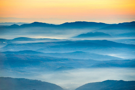 蓝色山和山在橙色日落背景