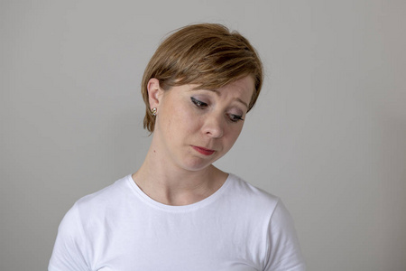 看着悲惨和忧郁.人类的面部表情和情绪概念.灰色背景照片