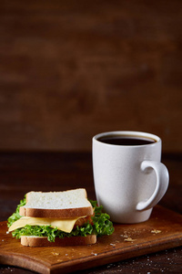 早餐桌与三明治和黑咖啡在质朴的木质背景, 特写, 选择性焦点