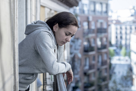站在阳台上的拉丁妇女感到不知所措和遭受抑郁症照片