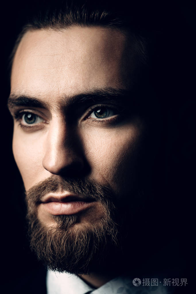 特写肖像的胡子英俊的年轻男子穿着优雅的衣服.