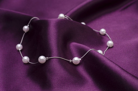 银色项链链与珍珠在丝绸被隔绝了