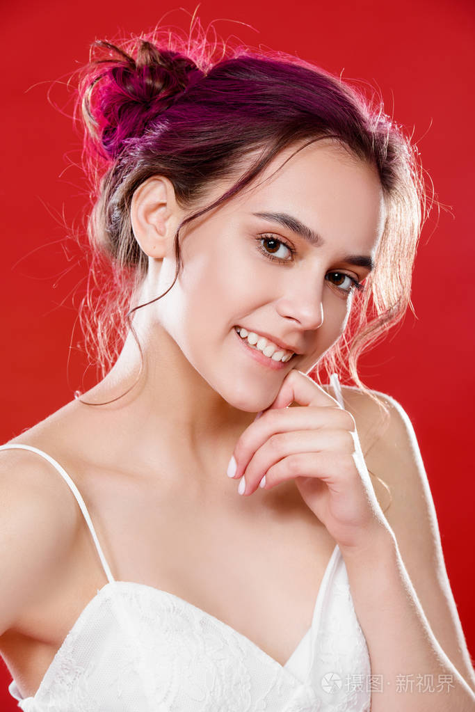 漂亮的粉红色头发的女孩摆在红色的背景.时尚美女青年风格