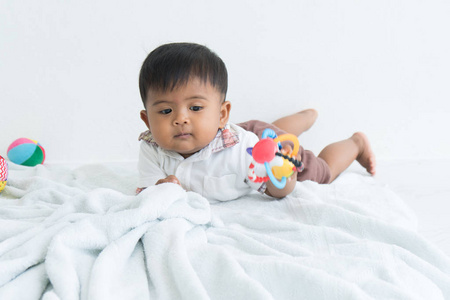 可爱的亚洲婴儿躺在柔软的毯子和玩球