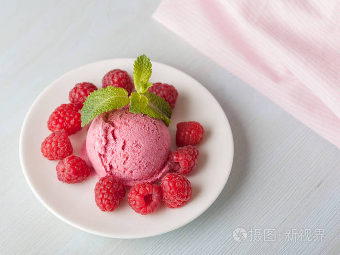 浆果和薄荷叶的树莓冰淇淋在光的背景下