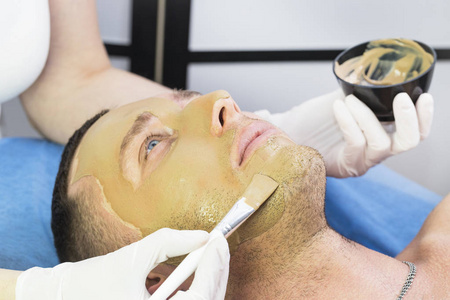 一个男人做的程序, 清洁他的脸, 用粘土面具在美容院