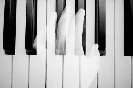 手合在钢琴上弹奏旋律。手机照片