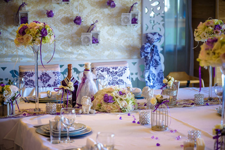 在豪华婚礼招待会上的餐桌设置。节日装饰的例子。新郎新娘桌上的真花