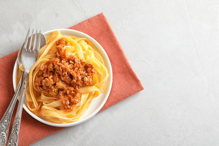 盘与美味的面食肉酱灰色背景, 顶部视图