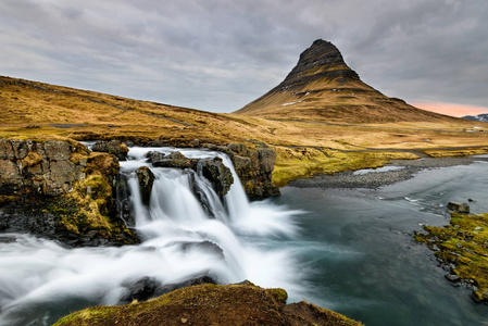 冰岛 Snaefellsnes 半岛北部海岸背景下的 Kirkjufellsfoss 瀑布顶部的令人惊叹的冰岛景观 Kirkju