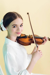有吸引力的十几岁的女孩演奏小提琴, 被隔绝在黄色