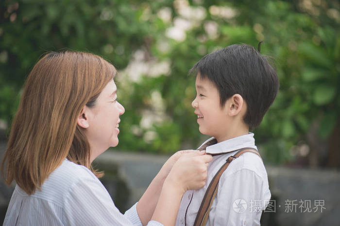亚洲妈妈说再见到她的儿子,当他离校,回学校概念