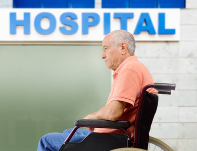 坐在轮椅上的病人等候下一所医院大楼