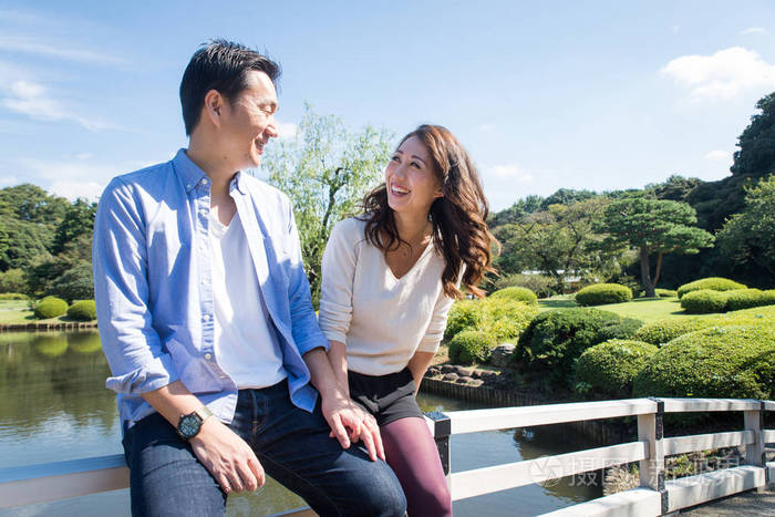 美丽的亚洲情侣在公园约会-日本男人和女人在户外玩得开心