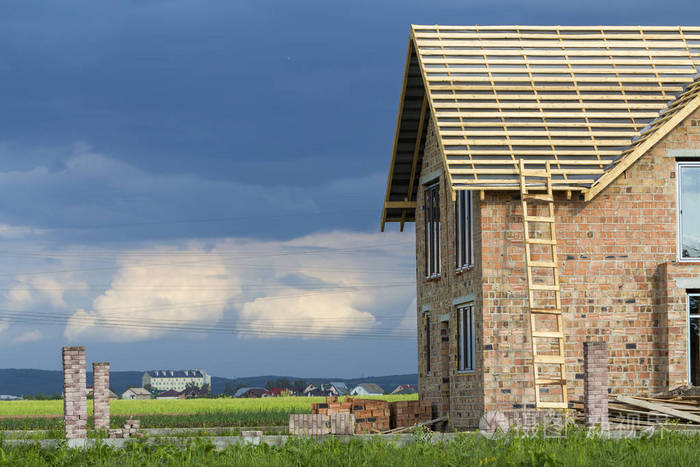 两层楼的房子木框架屋顶在建在红砖墙和砖堆的高木梯房地产开发理念