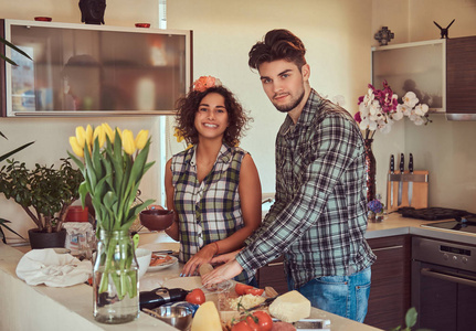 美丽的年轻夫妇在厨房做饭在家图片