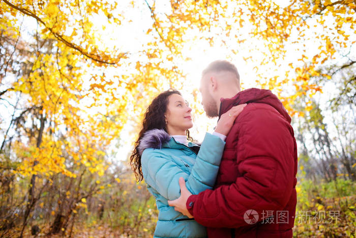 恩爱夫妻走在秋天的树林和拥抱