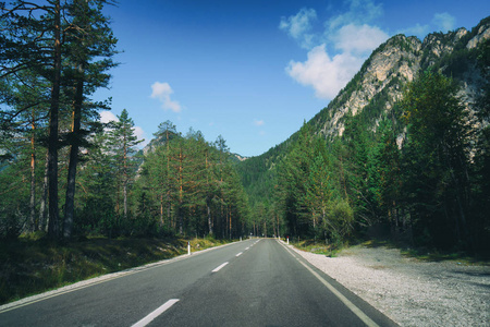 美丽的山路与树木, 森林和山脉的背景。在意大利白云岩山州公路公路上拍摄