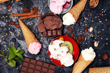 香草冻酸奶或软冰淇淋在华夫饼锥体在各种各样的口味和草莓冰淇淋照片