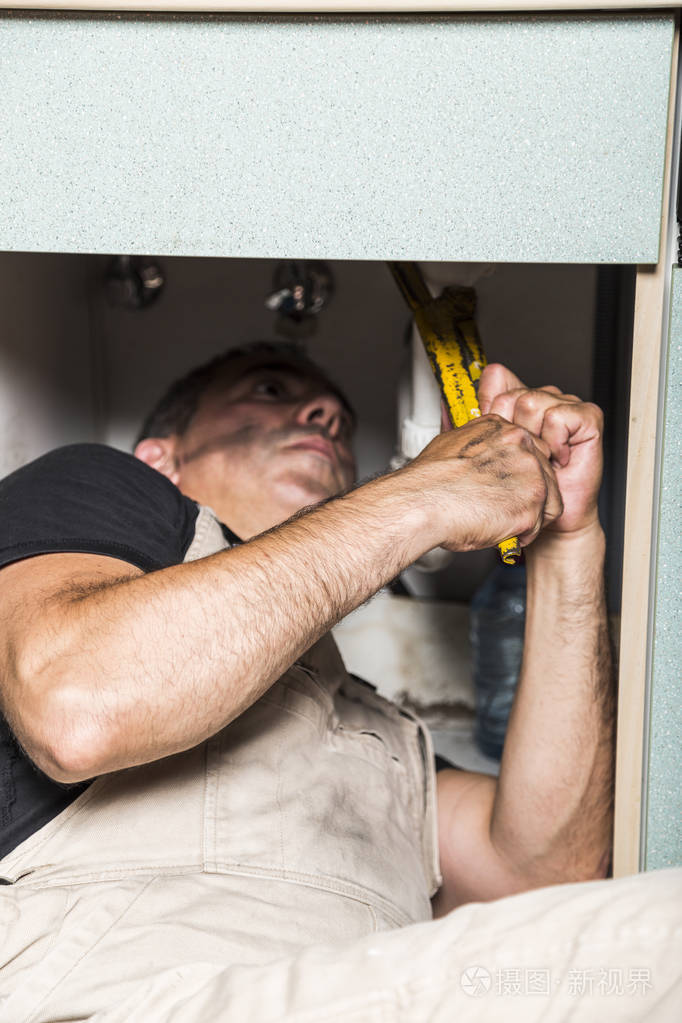 专业男性水管工修理厨房水龙头