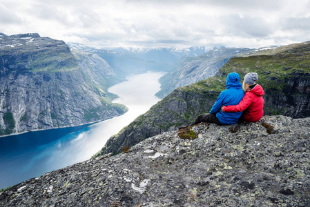 几个坐在岩石上，看着山在 Trolltunga 附近。最受欢迎的旅游胜地。Ringedalsvatnet在沃德在挪威特县自治市