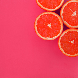 饱和的粉红色在明亮的背景粉红色的一些柚子切片的顶部视图.
