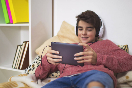青少年在家用耳机和平板电脑