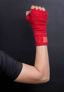 女性手在绷带与红色拳击磁带被上升作为权利斗争的标志。像女孩一样战斗