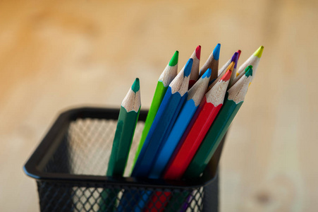 一束五颜六色的铅笔放在木桌上。绘画素描和学校用品。场浅景深