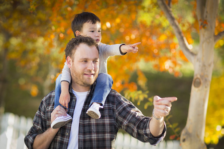 男孩的肩上混的血男孩骑背驮在肩上的白种人父亲照片
