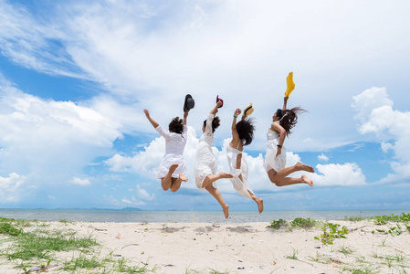 女人在海滩上愉快地跳了起来。旅行和 l