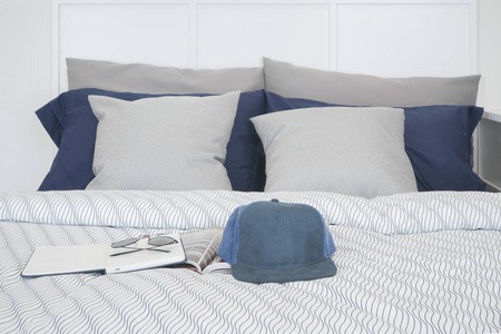 帽 笔记本和太阳镜的床上枕头在背景设置
