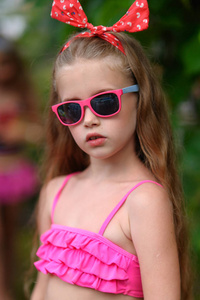 游泳池里热带风情小女孩的肖像图片
