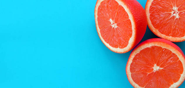 在明亮的背景蓝色的几个柚子切片的顶部视图。饱和柑橘纹理图像
