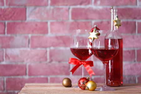 瓶红酒和眼镜上的背景墙上的圣诞礼物