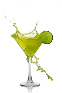 在绿色的含酒精的鸡尾酒饮料与石灰玻璃飞溅