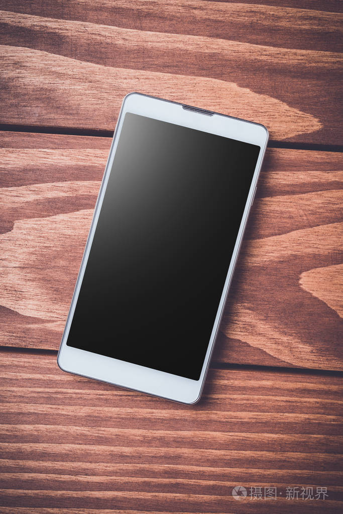 在木质背景智能手机.顶部视图