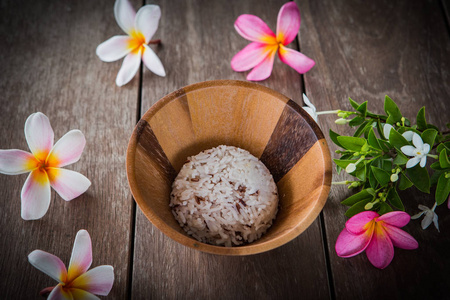 煮好的米饭上板煮好的米饭中木碗和桌子上的花照片