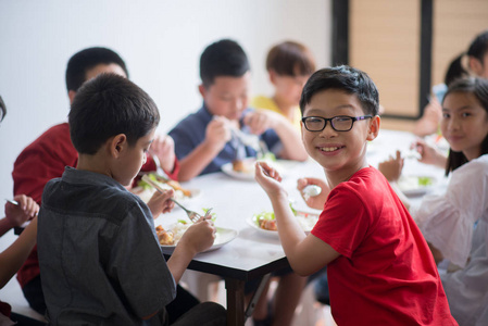 学生男孩和女孩一起午餐时间在学校食堂