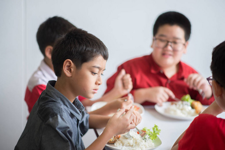 学生男孩和女孩一起午餐时间在学校食堂